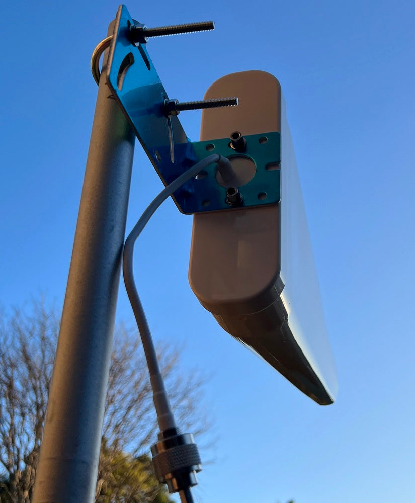 Antenna mount with blue bracket against a clear blue sky