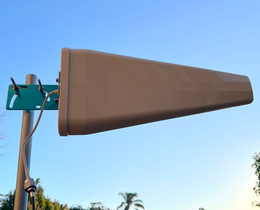 Beige antenna on a pole against a clear blue sky